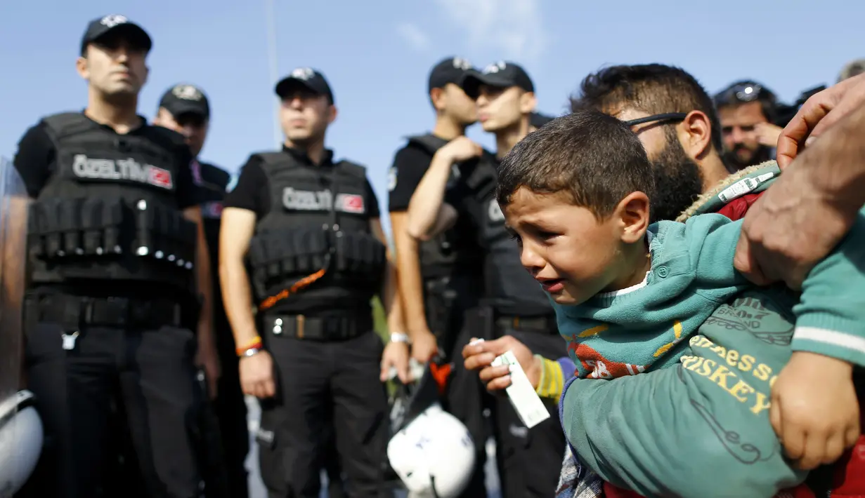 Seorang anak menangis saat bersama keluarganya berjalan menuju perbatasan Yunani di dekat Istanbul (21/9/2015). Ratusan imigran mencoba berjalan dari Istanbul ke kota barat Edirne, di perbatasan Yunani Turki. (REUTERS / Osman Orsal)