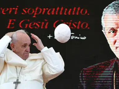 Zucchetto atau penutup kepala yang dikenakan Paus Fransiskus tertiup angin saat menghadiri upacara peringatan 25 tahun kematian Don Tonino Bello di Alessano, Italia (20/4). (AFP/Vincenzo Pinto)