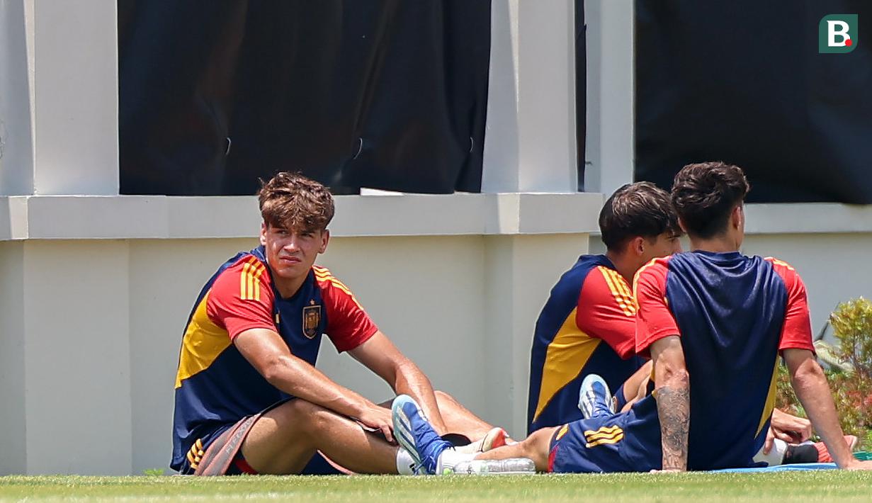 Ekspresi pemain Timnas Spanyol U-17, Marc Guiu (kiri), saat menjalani latihan dibawah sinar terik matahari yang berlangsung di Lapangan Sriwaru, Kecamatan Laweyan, Kota Solo, Rabu (8/11/2023). (Bola.com/Radifa Arsa)