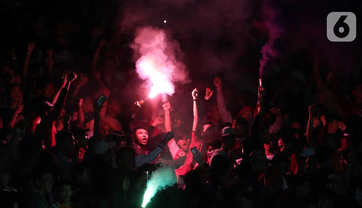 Suporter Persija menyalakan suar saat merayakan HUT ke-91 Persija dan kemenangan atas Persipura di laga lanjutan Shopee Liga 1 Indonesia 2019 di Stadion Utama Gelora Bung Karno, Jakarta, Kamis (28/11/2019). Persija unggul 1-0. (Liputan6.com/Helmi Fithriansyah)