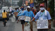 Pengemudi jeepney dengan poster “Bu / Pak, kami pengemudi jeepney, mohon bantuannya”, di sepanjang jalan di Manila, 12 Agustus 2020. Angkutan ikonik di Filipina itu belum dapat mengangkut penumpang sejak Maret akibat lockdown Covid-19 yang membuat jutaan orang kehilangan pekerjaan. (Ted ALJIBE/AFP)