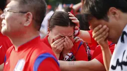 Ekspresi kesedihan tampak pada wajah beberapa warga Korea Selatan usai tim negaranya dikalahkan Belgia 0-1, Seoul, Jumat (27/6/14). (REUTERS/Kim Hong-Ji)