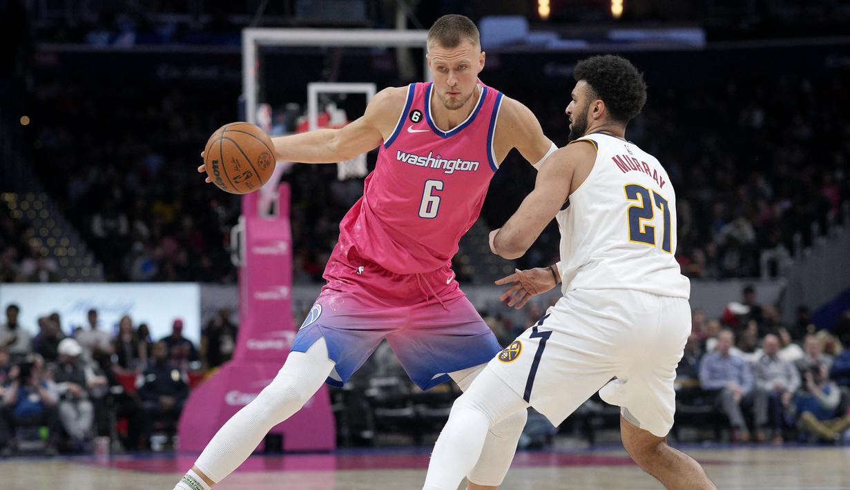 Pemain Washington Wizards, Kristaps Porzingis (kiri) berebut bola dengan pemain Denver Nuggets, Jamal Murray pada laga NBA 2023 di Capital One Arena, Washington, 22 Maret 2023. (AFP/Getty Images/Jess Rapfogel)
