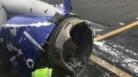 Petugas memeriksa kerusakan mesin pesawat yang membuat pesawat Southwest Airlines mendarat darurat di Philadelpia, Amerika Serikat, Selasa (17/4). Pesawat terbang selama 10 menit dengan satu mesin sebelum akhirnya mendarat darurat. (Amanda Bourman via AP)