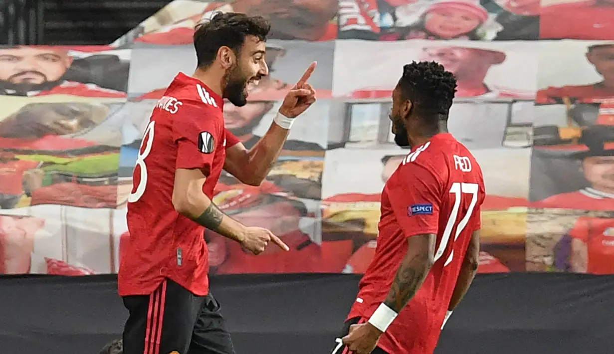 Gelandang Manchester United, Bruno Fernandes (kiri) melakukan selebrasi usai mencetak gol pertama timnya ke gawang AS Roma dalam laga leg pertama semifinal Liga Europa 2020/2021 di Old Trafford Stadium, Manchester, Kamis (29/4/2021). Manchester United menang 6-2 atas AS Roma. (AFP/Paul Ellis)