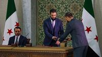 Presiden sementara Suriah, Ahmed al-Sharaa, menerima konstitusi sementara Suriah dalam upacara penandatanganan.&nbsp;(Dok. Omar Albam/AP)