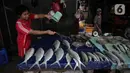 Pedagang menyiram ikan bandeng di Pasar Petak Sembilan, Glodok, Jakarta, Senin (31/1/2022). Harga dari ikan bandeng tersebut bervariasi, mulai dari Rp 50 ribu sampai Rp 90 ribu per kilogram tergantung ukuran ikan. (Liputan6.com/Faizal Fanani)
