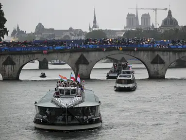 Kapal yang membawa kontingan Indonesia menyusuri sungai Seine saat pembukaan Olimpiade Paris 2024 di Paris, Prancis, Kamis (26/7/2024). (SEBASTIEN BOZON / AFP)