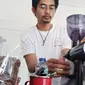 Salah satu barista De'Yons Cafe and Eatery Garut tengah menyajikan kopi Garut bagi pengunjung yang datang. (Liputan6.com/Jayadi Supriadin)