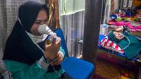 Warga yang terpapar kabut asap karhutla menghirup oksigen ketika berada di Rumah Singgah Korban Asap di Pekanbaru, Riau, Jumat (20/9/2019). Data Kemenkes sebanyak 15.346 warga di Provinsi Riau menderita ISPA akibat kabut asap karhutla dalam kurun waktu September 2019. (Wahyudi/AFP)