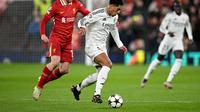 Bek Liverpool asal Skotlandia Andrew Robertson berebut bola dengan gelandang Real Madrid asal Inggris Jude Bellingham selama pertandingan sepak bola Liga Champions UEFA antara Liverpool dan Real Madrid di Anfield, Liverpool, Inggris barat laut pada 27 November 2024.Oli SCARFF / AFP