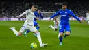 Gelandang Real Madrid, Federico Valverde berusaha mengumpan bola dari kawalan pemain Getafe, Carles Alena pada pertandingan lanjutan La Liga Spanyol di stadion Santiago Bernabeu di Madrid, Minggu (10/4/2022). Real Madrid menang atas Getafe 2-0. (AP Photo/Manu Fernandez)