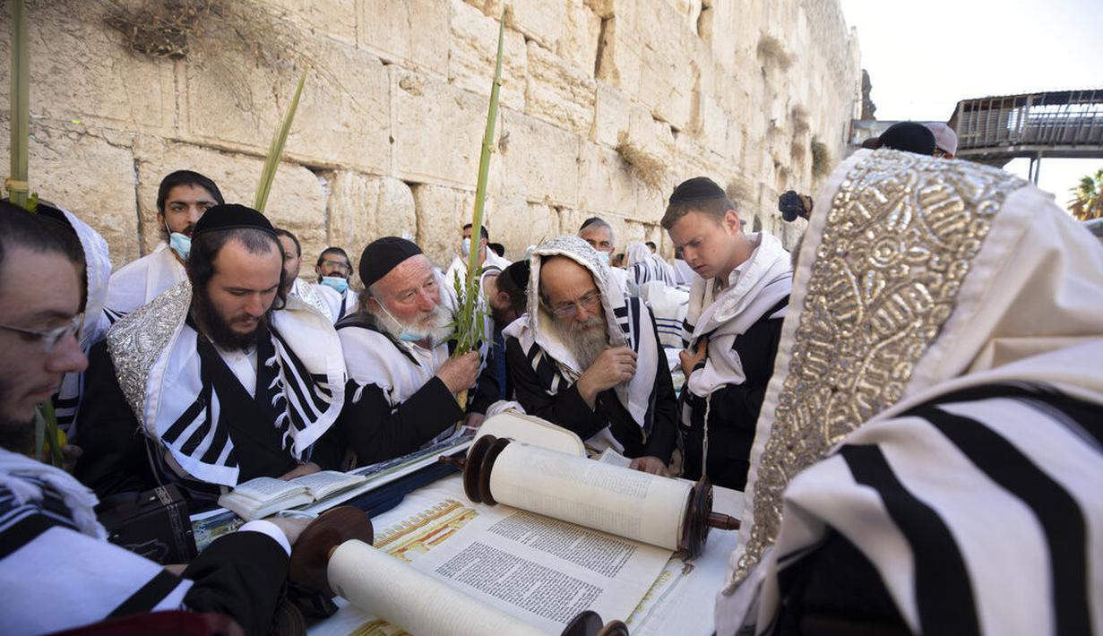 Pria Yahudi Ultra-Ortodoks berdoa selama hari raya Yahudi Sukkot di Tembok Barat, situs paling suci di mana orang Yahudi dapat berdoa di Kota Tua Yerusalem, Rabu (22/9/2021).  (AP Photo/Sebastian Scheiner)