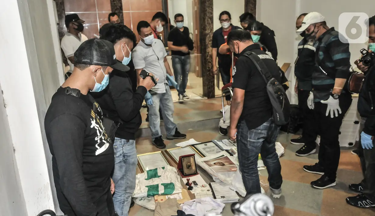 tugas kepolisian mengumpulkan hasil temuan saat penggeledahan di eks Kantor DPP Front Pembela Islam (FPI), Petamburan, Jakarta, Selasa (27/4/2021). Polisi mengamankan barang bukti seperti bendera tauhid, buku, bahan berbahaya, dan atribut FPI. (merdeka.com/Iqbal S.Nugroho)