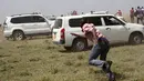 Warga berlarian ke tempat yang aman setelah seekor singa menyerang dan melukai pejalan kaki, di luar ibu kota Kenya, Nairobi, Rabu (30/3). Ini adalah kali keempat singa berkeliaran keluar dari Taman Nasional Nairobi. (REUTERS/Stringer)