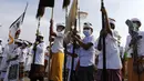 Anak-anak mencelupkan kaki ke laut saat mengikuti ritual Melasti di Bali, Senin (28/2/2022). Ritual yang dilakukan menjelang Hari Raya Nyepi umat Hindu ini diadakan untuk menyucikan alam semesta dari pengaruh buruk, perbuatan dan pikiran buruk. (AP Photo/Firdia Lisnawati)