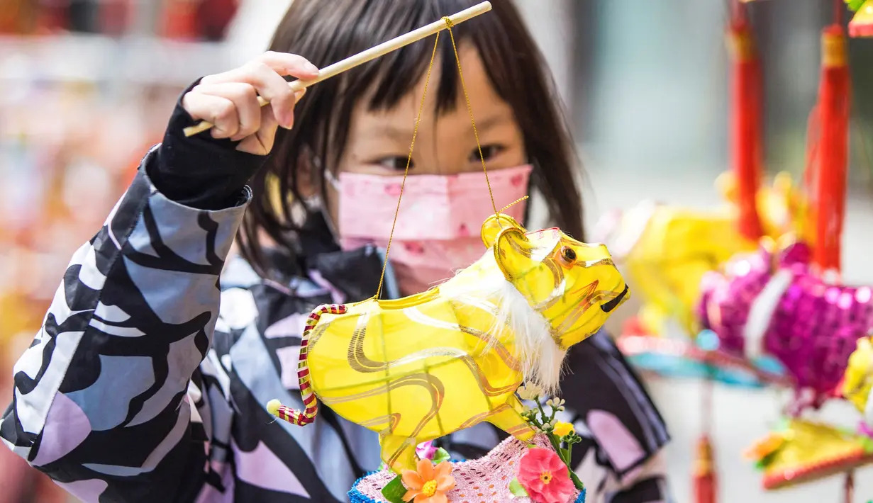 Seorang anak memegang lentera menjelang Festival Lampion, yang jatuh pada 15 Februari tahun ini - hari ke-15 Tahun Baru Imlek - di Nanjing di provinsi Jiangsu timur China pada 10 Februari 2022. Festival Lampion merupakan puncak sekaligus penutup dari perayaan Tahun Baru Imlek. (STR / AFP)