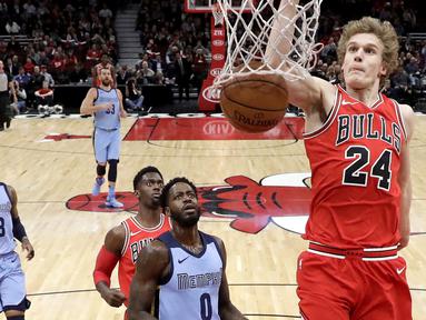 Aksi pemain Chicago Bulls, Lauri Markkanen #24 melakukan dunks saat melawan Memphis Grizzlies pada lanjutan NBA basketball game di United Center, Chicago, (7/3/2018). Chicago Bulls menang 119-110. (AP/Charles Rex Arbogast)