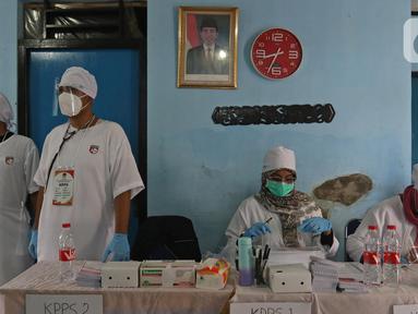 Petugas menggunakan atribut dokter saat Pilkada Depok di Tempat Pemungutan Suara (TPS) 56, Mekarjaya, Depok, Rabu (9/12/2020). TPS dengan tema kesehatan itu bertujuan menarik warga menggunakan hak pilih dan mengingatkan protokol kesehatan di masa Pandemi COVID-19.  (Liputan6.com/Herman Zakharia)