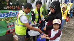 Aktivis lingkungan membagikan kantong belanja nonplastik saat sosialisasi pengurangan penggunaan kantong plastik di Sempur, Bogor, Minggu (25/11). Perwali Kota Bogor tentang kantong plastik akan belaku mulai 1 Desember 2018. (Merdeka.com/Arie Basuki)