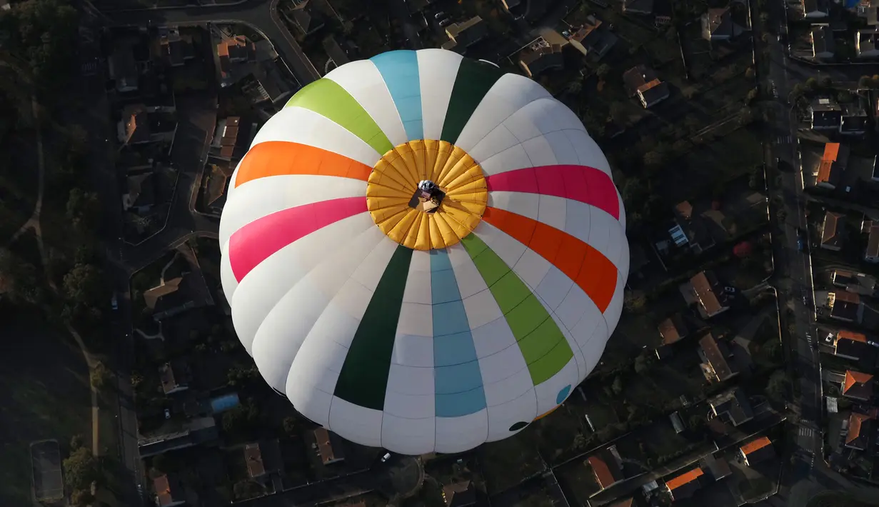 Balonist Prancis Remi Ouvrard mencoba memecahkan rekor dunia dengan berdiri di atas balon udara panas di Chatellerault, Rabu (10/11/2021). Ketinggian harus sama dengan nomor telepon kampanye Telethon 36-37, penggalangan dana tahunan Prancis untuk penelitian medis. (Guillaume SOUVANT/AFP)