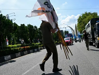 Anggota Satpol PP menertibkan alat peraga kampanye (APK) Pemilu 2024 di kawasan terlarang di Banda Aceh, Aceh, Kamis (11/1/2024). Penertiban ini dilakukan menjelang pemilu yang dijadwalkan digelar pada 14 Februari. (CHAIDEER MAHYUDDIN/AFP)