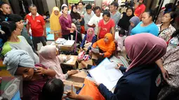 Puluhan warga antri mendapat bantuan alat mandi di dalam Masjid Raya Universitas Borobudur, Jakarta, Senin (20/2). Ratusan warga Cipinang Melayu terpaksa mengungsi akibat banjir yang menggenangi pemukiman mereka. (Liputan6.com/Helmi Fithriansyah)