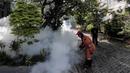 Petugas melakukan pengasapan (fogging) ke bagian selokan kawasan rumah warga, Pesanggrahan, Jakarta, Kamis (6/10/2022). Selokan menjadi sarang berkembangbiak nyamuk Aedes Aegypti. (Liputan6.com/Johan Tallo)