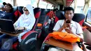 Penumpang Bus Harapan Jaya menggunakan laptop dan charger handphone yang merupakan fasilitas bus di Pool Ciputat, Tangerang Selatan. Penumpang bisa menggunakan fasilitas seperti wi fi, charger listrik dan USB. (Liputan6.com/Fery Pradolo)