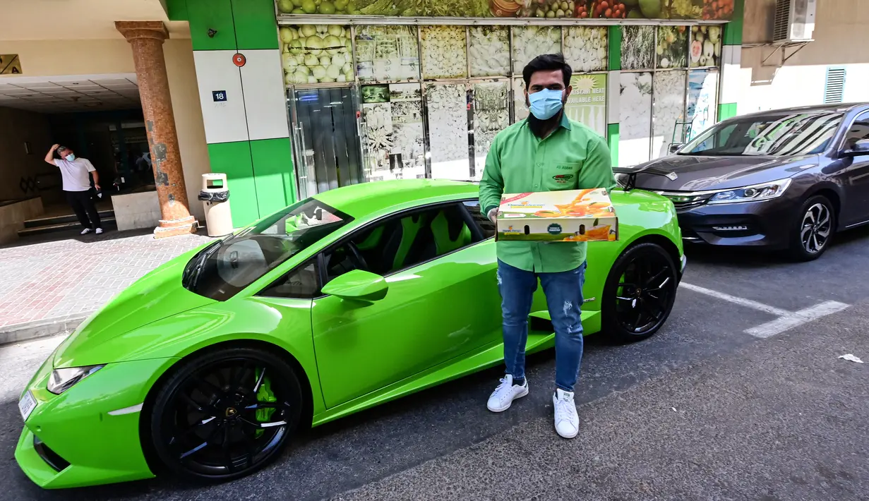 Direktur Pelaksana Pakistan Supermarket Dubai Muhammad Jehanzeb berdiri dekat Lamborghini Huracan sebelum mengirim pesanan mangga di Dubai, Uni Emirat Arab, Kamis (2/7/2020). Supermarket tersebut mengantarkan pesanan mangga untuk minimal pesanan sekitar USD 27. (CACACE GIUSEPPE/AFP)