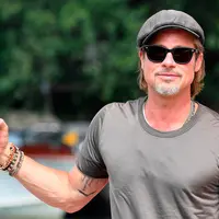 Aktor Brad Pitt berpose saat tiba di Pantai Lido untuk menghadiri Venice Film Festival 2019, Venesia, Italia, Rabu (28/8/2019). Brad Pitt tampak santai dengan mengenakan celana jeans hitam, kaus oblong, kaca mata hitam, dan topi newsboy cap. (Ettore Ferrari/ANSA via AP)