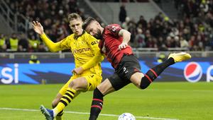 Olivier Giroud dari AC Milan, kanan, berebut bola dengan pemain Dortmund Nico Schlotterbeck pada pertandingan sepak bola grup F Liga Champions antara AC Milan dan Borussia Dortmund di stadion San Siro di Milan, Italia, Selasa, 28 November 2023. (AP Photo /Antonio Calanni)