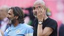 Pelatih Manchester City, Pep Guardiola (kanan), menyeka air matanya setelah berhasil membawa timnya keluar sebagai juara Piala FA 2022/2023 dalam pertandingan final melawan Manchester United yang berlangsung di Wembley, Sabtu (3/6/2023) WIB. (AP Photo/Dave Thompson)
