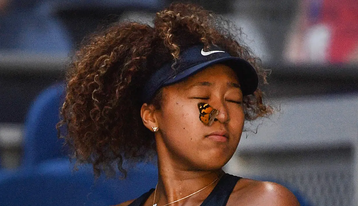 Seekor kupu-kupu mendarat di wajah petenis asal Jepang, Naomi Osaka dalam pertandingan tunggal putri Australia Terbuka di Melbourne pada 12 Februari 2021. (AFP/Paul Crock)