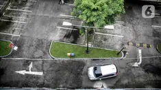 Sebuah mobil melintas di lahan parkir yang sepi di sebuah gedung, Jakarta, Kamis (1/5/2020). Indonesia Parking Association (IPA) menyatakan terjadi penurunan bisnis parkir sebesar 75-90 persen seiring penerapan PSBB untuk mencegah penyebaran COVID-19 di Jabodetabek. (Liputan6.com/Faizal Fanani)