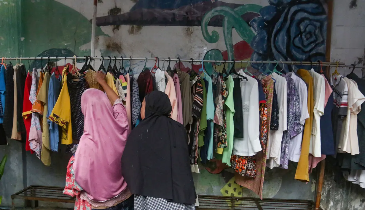 Bantuan yang dibagikan berupa pakaian layak pakai dan bahan makanan yang berasal dari sumbangan warga sekitar. Tampak dalam foto, warga memilih pakaian layak pakai yang dibagikan secara cuma-cuma di permukiman RT 02/RW 04 kawasan Jati Padang, Jakarta, Jumat (6/3/2026). (merdeka.com/Arie Basuki)