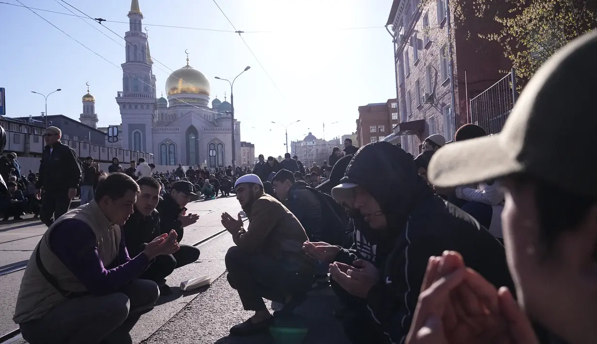 Sekelompok pria Sholat saat umat Islam lainnya meninggalkan kawasan itu selama perayaan liburan Idul Fitri di Masjid Katedral Moskow, masjid utama Moskow, terbesar di Rusia dan Eropa di Moskow, Rusia, Jumat dini hari, 21 April 2023. (AP Photo/Alexander Zemlianichenko)