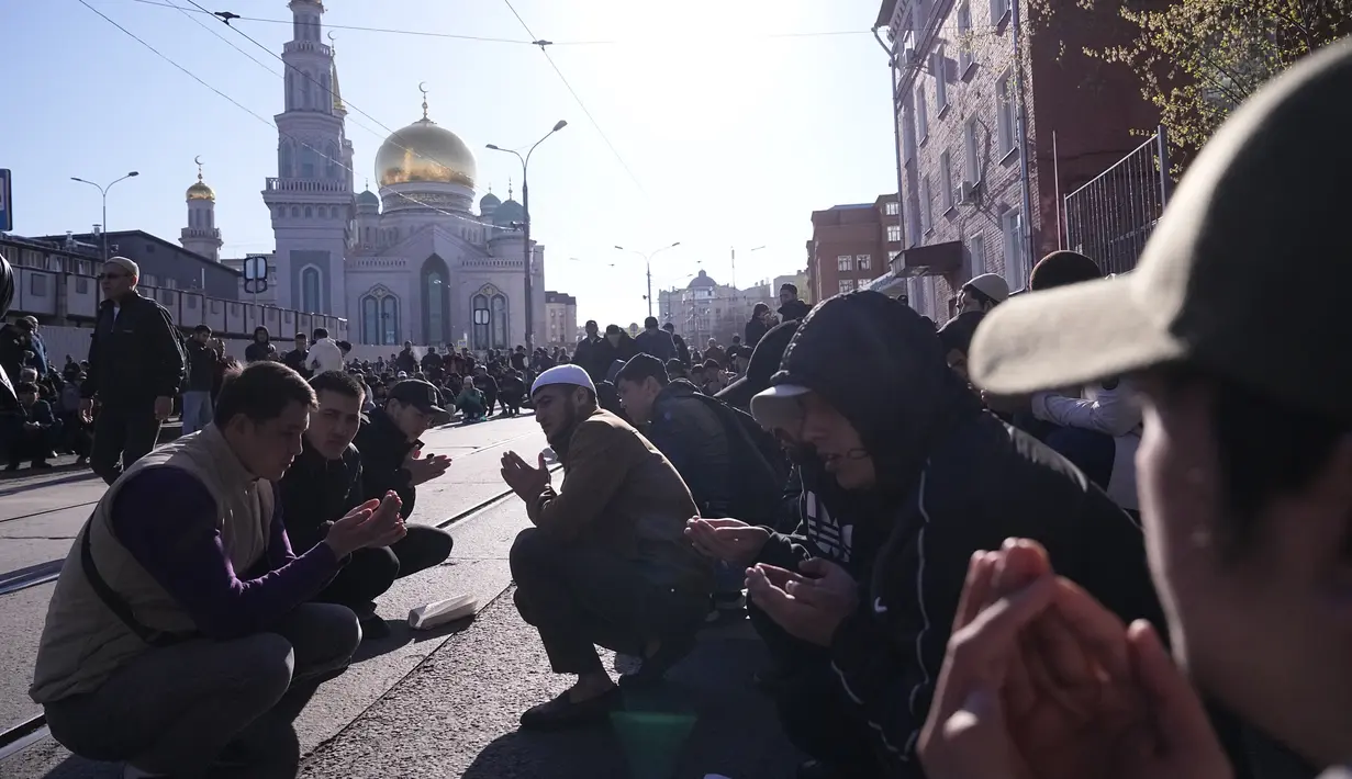 Sekelompok pria Sholat saat umat Islam lainnya meninggalkan kawasan itu selama perayaan liburan Idul Fitri di Masjid Katedral Moskow, masjid utama Moskow, terbesar di Rusia dan Eropa di Moskow, Rusia, Jumat dini hari, 21 April 2023. (AP Photo/Alexander Zemlianichenko)