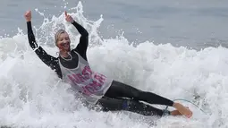 Peserta memakai topeng capres AS, Hillary Clinton saat mengikuti kontes surfing Haunted Heats Halloween di Santa Monica, AS (29/10). Acara ini untuk merayakan hari Halloween yang jatuh pada tanggal 31 Oktober. (REUTERS/Lucy Nicholson)