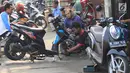 Mekanik memperbaiki motor di salah satu bengkel di Otista, Jakarta, Minggu (10/6). Calon pemudik motor mulai memenuhi bengkel guna menyervis atau mengganti suku cadang kendaraan sebelum digunakan untuk mudik Lebaran. (Liputan6.com/Angga Yuniar)