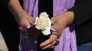 Seorang wanita memegang bunga mawar saat melakukan aksi jelang jelang Hari Penghapusan Kekerasan Perempuan Internasional di pemakaman Juarez, Negara Bagian Chihuahua, Meksiko, (24/11). (AFP Photo/Herika Martinez)
