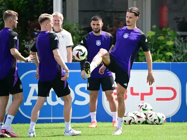 Bek Jerman #24 Robin Koch (kanan) dan rekan satu timnya mengambil bagian dalam sesi latihan MD-1 menjelang pertandingan Grup A UEFA EURO 2024 di Herzogenaurach, Bavaria, Selasa (18/6/2024). (Tobias SCHWARZ / AFP)