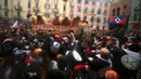 Sejumlah peserta saling lempar jeruk saat perang-perangan selama karnaval di kota Ivrea, Italia, Minggu (7/2). Peserta yang dibagi menjadi dua tim ini saling melempar jeruk menggunakan kostum dan aksesoris lengkap. (REUTERS/Stefano Rellandini)