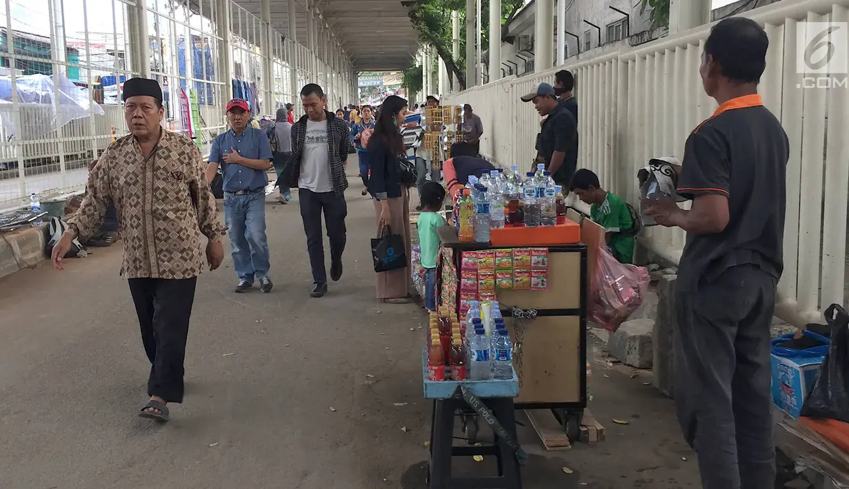 PKL berjualan di kolong skybridge atau JPM Tanah Abang, Jakarta, Rabu (7/11). Molornya pembangunan skybridge menyebabkan PKL kembali menjajakan dagangannya, meskipun telah dilarang oleh Pemprov DKI Jakarta. (Liputan6.com/Immanuel Antonius)