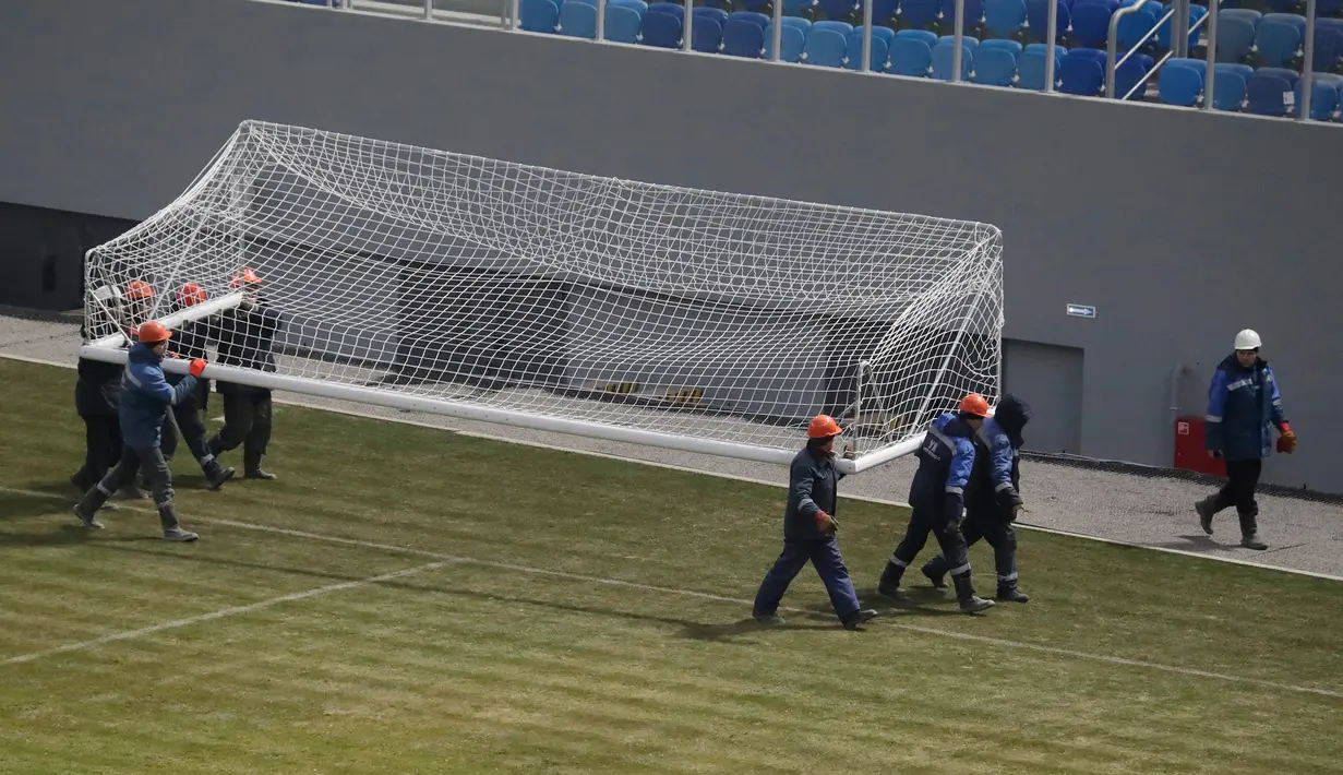 Pekerja membawa tiang gawang di dalam stadion sepak bola, yang sedang dibangun di Krestovsky akan menjadi tuan rumah untuk beberapa pertandingan sepak bola Piala Dunia 2018 di St.Petersburg, Rusia, (29/12/2016). (AP Photo / Dmitri Lovetsky)