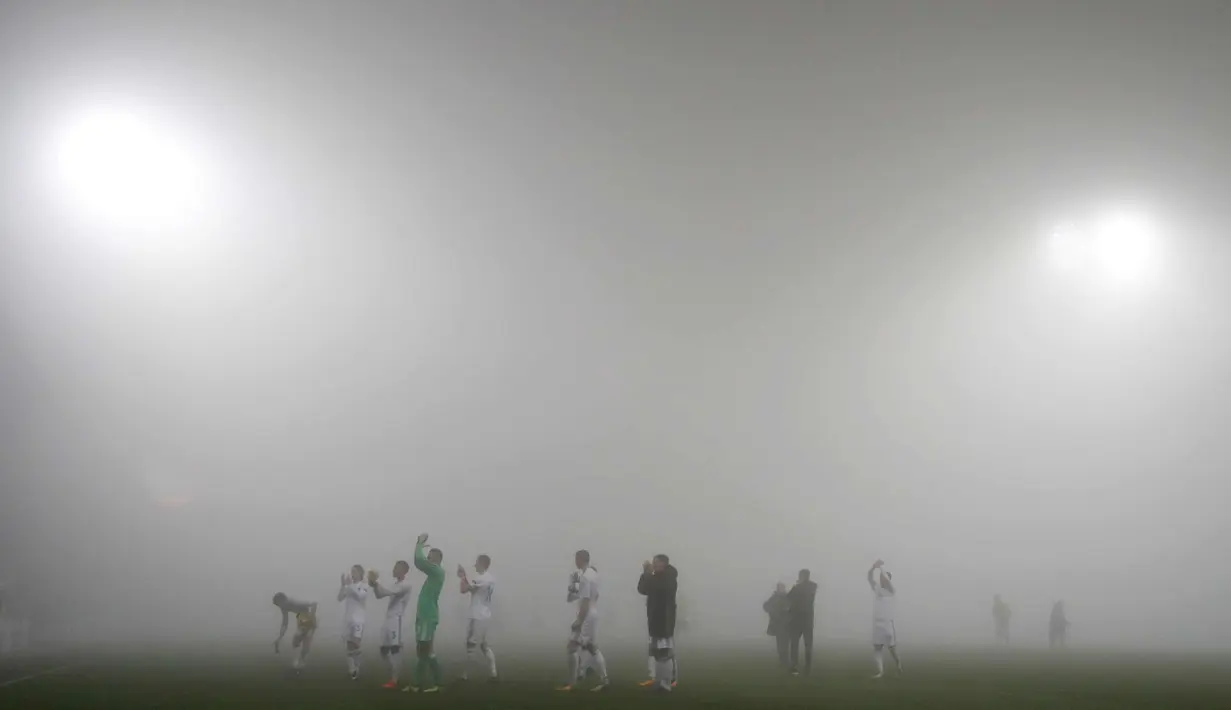 Para pemain F.C. Copenhagen menyapa suporter usai pertandingan melawan FC Fastav Zlin pada Grup F Liga Europa di Stadion Andruv, Ceko (19/10). Kabut tebal mendadak menutup stadion yang menyebabkan berkurangnya jarak pandang. (AP Photo/Petr David Josek)