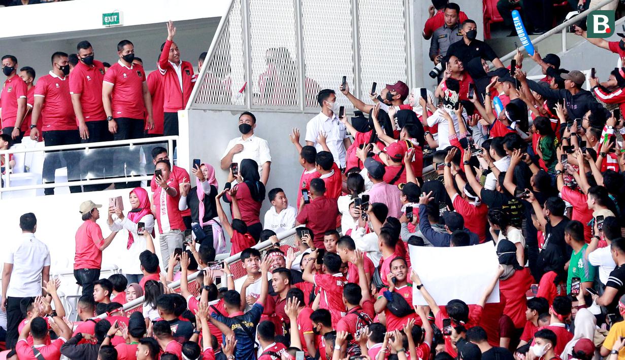 Presiden RI, Joko Widodo, menyapa suporter saat menyaksikan pertandingan Timnas Indonesia melawan Thailand pada laga Piala AFF 2022 di Stadion Utama Gelora Bung Karno (SUGBK), Jakarta, Kamis (29/12/2022). (Bola.com/M Iqbal Ichsan)
