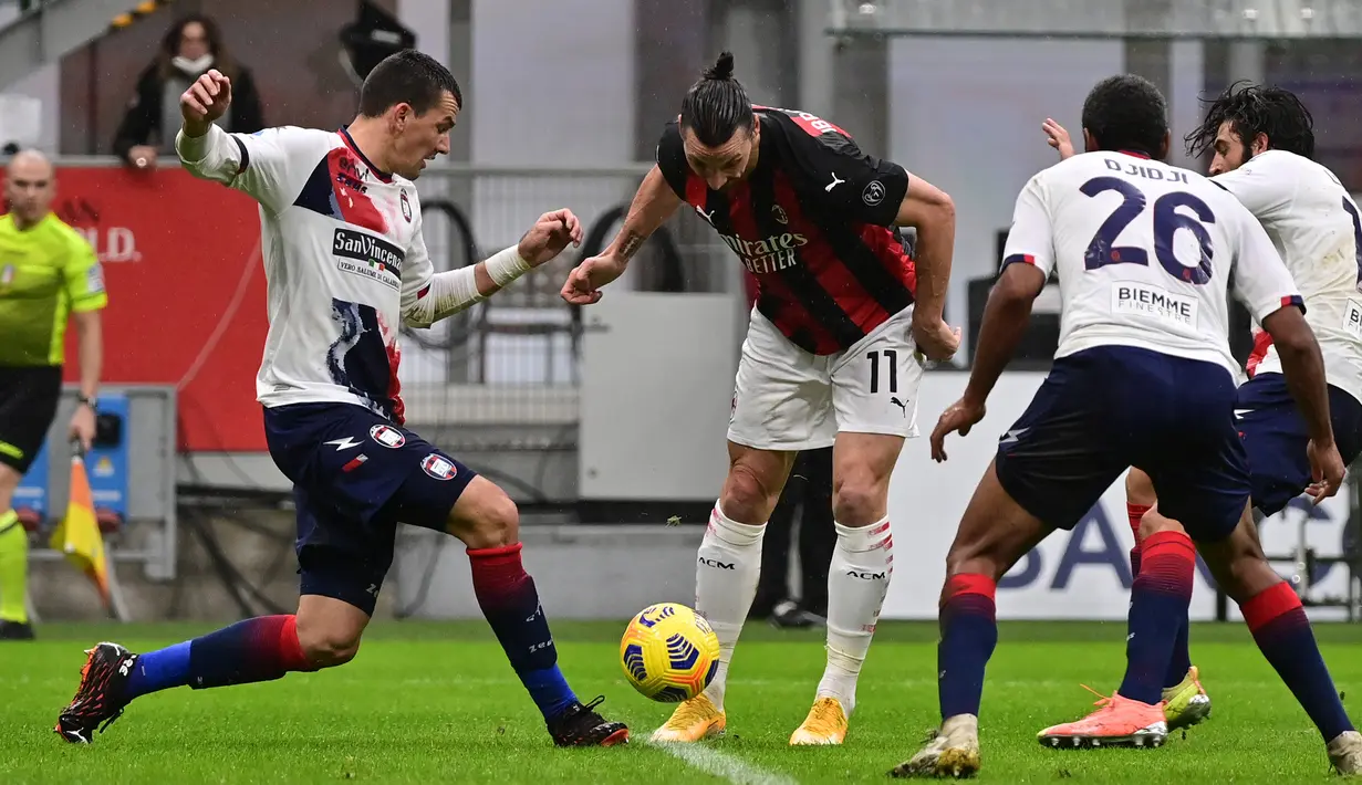 Striker AC Milan, Zlatan Ibrahimovic (tengah) dikepung tiga pemain Crotone dalam laga lanjutan Liga Italia 2020/21 pekan ke-21 di San Siro Stadium, Milan, Minggu (7/2/2021). AC Milan menang 4-0 atas Crotone. (AFP/Miguel Medina)