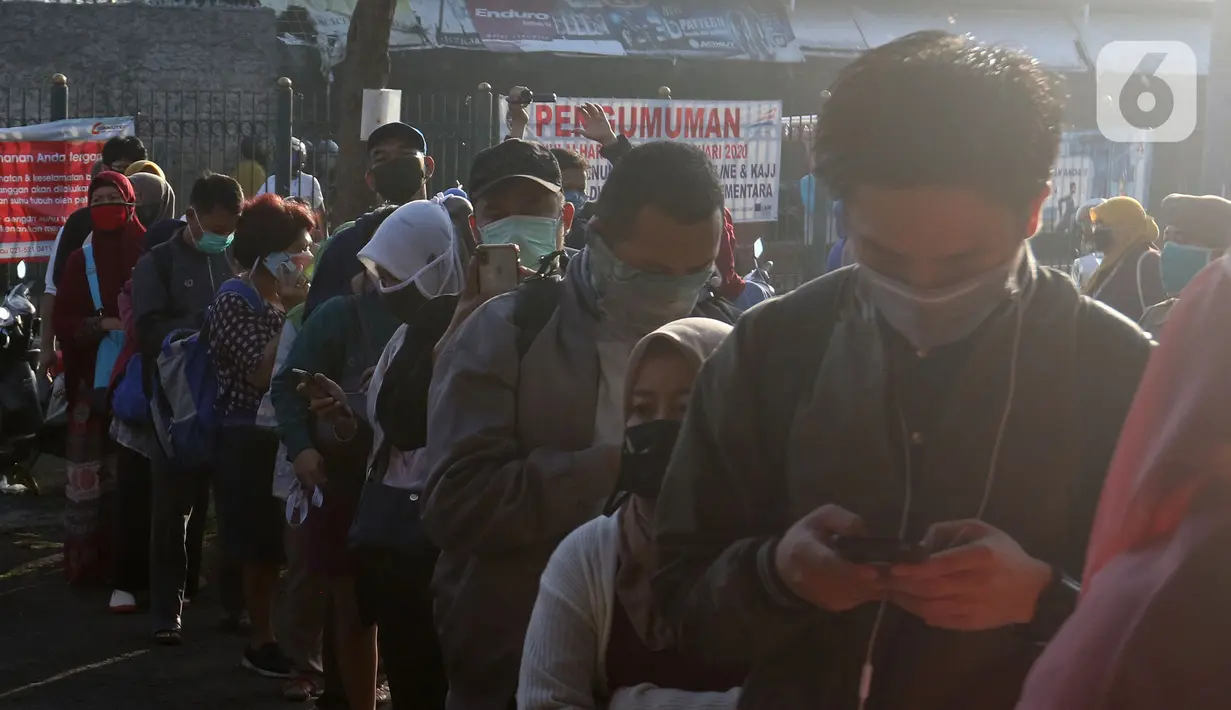 Calon penumpang KRL Commuter Line mengenakan masker antre memasuki Stasiun Bekasi, Selasa (5/5/2020). Pihak Stasiun Bekasi menerapkan jaga jarak antar penumpang, membatasi jumlah penumpang hingga 50% dan membatasi jam operasional dari pukul 06.00 hingga 18.00. (Liputan6.com/Herman Zakharia)