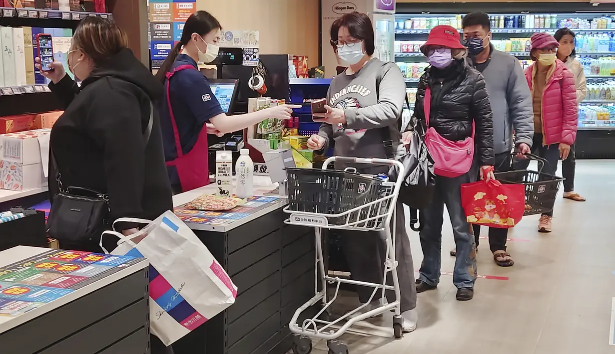 Orang-orang memakai masker saat berbelanja di supermarket di Taipei, Taiwan, Senin (20/2/2023). Meski Taiwan mencabut aturan masker di dalam ruangan, di jalanan Taipei dan di gedung perkantoran, banyak orang tetap memakai penutup wajah. (AP Photo/Chiang Ying-ying)